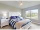 Bright bedroom with a white bed frame, blue and white bedding, and a large window at 6307 Hanfield Dr, Port Orange, FL 32128