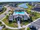 An aerial view shows a community pool area with a pool, clubhouse, playground, parking lot and surrounding homes at 6307 Hanfield Dr, Port Orange, FL 32128