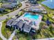 Aerial view of a community pool with lounge seating, a playground, and a clubhouse with a dark roof at 6307 Hanfield Dr, Port Orange, FL 32128