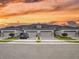 Elegant townhome with a three-car garage, pristine landscaping, and a picturesque sunset backdrop at 6307 Hanfield Dr, Port Orange, FL 32128