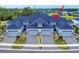 Stunning aerial view of townhomes with paved driveways, manicured landscaping and blue toned roofs at 6307 Hanfield Dr, Port Orange, FL 32128