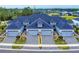 Stunning aerial view of townhomes with paved driveways, manicured landscaping and blue toned roofs at 6307 Hanfield Dr, Port Orange, FL 32128