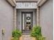 Inviting front door with decorative wreath, flanked by stone columns and lush ferns at 6307 Hanfield Dr, Port Orange, FL 32128