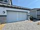 View of private garage with retractable screen door and paved driveway at 6307 Hanfield Dr, Port Orange, FL 32128