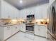 Bright kitchen features white cabinetry, stainless steel appliances, and a decorative tile backsplash at 6307 Hanfield Dr, Port Orange, FL 32128