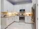 Bright kitchen features white cabinetry, stainless steel appliances, and a decorative tile backsplash at 6307 Hanfield Dr, Port Orange, FL 32128