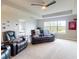 Comfortable living room with a black leather couch, chair, ceiling fan, and view of the lawn at 6307 Hanfield Dr, Port Orange, FL 32128