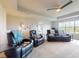 Comfortable living room with a black leather couch and chair, ceiling fan, and neutral color palette at 6307 Hanfield Dr, Port Orange, FL 32128