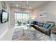 Cozy living room with a plush sofa, ceiling fan, and access to outdoor patio at 6307 Hanfield Dr, Port Orange, FL 32128