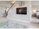 Open living area with a large TV, staircase, and views of the kitchen and bedroom at 6307 Hanfield Dr, Port Orange, FL 32128