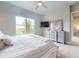 The main bedroom features a large window and a dresser with a mirror and a TV at 6307 Hanfield Dr, Port Orange, FL 32128