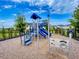 View of the community playground with climbing structure, slides, and other playground equipment on wood chip surface at 6307 Hanfield Dr, Port Orange, FL 32128