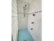 Walk-in shower featuring blue-green tile, glass blocks and shower head at 6340 Engram Rd, New Smyrna Beach, FL 32169