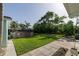 Spacious backyard features a pool, grass lawn, lush greenery and a stone-tiled walkway at 653 Goodwin Ave, New Smyrna Beach, FL 32169