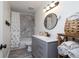 Bathroom with modern vanity, round mirror, and a shower/tub with decorative curtain at 653 Goodwin Ave, New Smyrna Beach, FL 32169