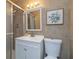 Well-lit bathroom featuring a white vanity, toilet, and shower with tiled walls at 653 Goodwin Ave, New Smyrna Beach, FL 32169
