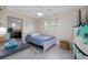 Cozy bedroom setup with a bed, desk, a surfboard, and good natural light at 653 Goodwin Ave, New Smyrna Beach, FL 32169