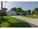 Charming exterior view of light blue home, showcasing a well-manicured lawn, driveway, and a two-car garage at 653 Goodwin Ave, New Smyrna Beach, FL 32169