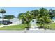 Charming exterior view of light blue home, showcasing a well-manicured lawn, driveway, and palm trees at 653 Goodwin Ave, New Smyrna Beach, FL 32169