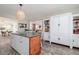 Kitchen showcasing a center island with room for seating, white cabinets, a view to the dining room, and hardwood-style floors at 653 Goodwin Ave, New Smyrna Beach, FL 32169