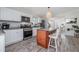 Bright kitchen boasts a center island with seating, white cabinets, stainless steel appliances, and hardwood-style floors at 653 Goodwin Ave, New Smyrna Beach, FL 32169
