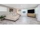 Bright living room with hardwood-style floors, neutral paint, large sectional, and modern entertainment console at 653 Goodwin Ave, New Smyrna Beach, FL 32169
