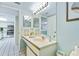Well-lit bathroom featuring a vanity with sink and a view into the connected kitchen space at 6727 Turtlemound Rd # 318, New Smyrna Beach, FL 32169