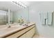 Bathroom with a double vanity, framed mirror, and walk-in shower creating a functional and stylish space at 6727 Turtlemound Rd # 318, New Smyrna Beach, FL 32169