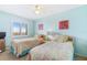 Bright bedroom featuring two twin beds, cheerful decor, and natural light, perfect for a comfortable and inviting space at 6727 Turtlemound Rd # 318, New Smyrna Beach, FL 32169