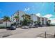 Spacious condo building exterior with ample parking, complemented by lush palm trees and greenery, offering a serene environment at 6727 Turtlemound Rd # 318, New Smyrna Beach, FL 32169