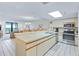 Bright kitchen featuring white cabinets, stainless steel appliances, and a breakfast bar with views into the living area at 6727 Turtlemound Rd # 318, New Smyrna Beach, FL 32169