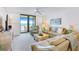 Comfortable living room with a ceiling fan and sliding doors to the ocean view balcony at 6727 Turtlemound Rd # 318, New Smyrna Beach, FL 32169