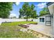 Spacious backyard with a concrete patio, fire pit, green lawn, shed, and a white vinyl fence at 680 Buford Ave, Orange City, FL 32763