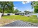 Expansive backyard with a wood deck, patio with a fire pit, green lawn and a shed at 680 Buford Ave, Orange City, FL 32763