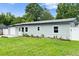 Charming single-story home with a well-maintained lawn and light blue siding, located on a tree-lined street at 680 Buford Ave, Orange City, FL 32763