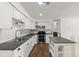Modern kitchen features white cabinets, a dark countertop, stainless steel appliances, and a breakfast bar at 680 Buford Ave, Orange City, FL 32763