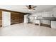Open-concept living space features a wood accent wall, tile flooring, kitchen with island, and stainless steel appliances at 680 Buford Ave, Orange City, FL 32763