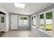 Bright sun room features tile flooring, gray wall paneling, white trim, and multiple windows for natural light at 680 Buford Ave, Orange City, FL 32763