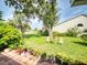 Lush backyard featuring green grass, mature trees, and a cozy seating area at 686 Middlebury Loop, New Smyrna Beach, FL 32168