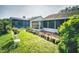 Landscaped backyard with lush green lawn, brick patio, and screened-in pool area for outdoor enjoyment and relaxation at 686 Middlebury Loop, New Smyrna Beach, FL 32168