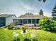 Well-maintained backyard with a screened-in porch, lush green grass, and patio area at 686 Middlebury Loop, New Smyrna Beach, FL 32168