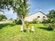 Relaxing backyard featuring lush green lawn, mature trees, and cozy seating area, ideal for outdoor enjoyment at 686 Middlebury Loop, New Smyrna Beach, FL 32168