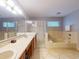 Bathroom featuring double sinks, a large mirror, a shower, and a tub at 686 Middlebury Loop, New Smyrna Beach, FL 32168