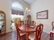 Dining room with hardwood floors, decorative chandelier, and large window at 686 Middlebury Loop, New Smyrna Beach, FL 32168