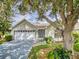 Charming single-story home with well-maintained lawn, mature tree, and attached two-car garage at 686 Middlebury Loop, New Smyrna Beach, FL 32168