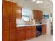 Kitchen featuring hardwood cabinets, tile floor, and a bright window at 686 Middlebury Loop, New Smyrna Beach, FL 32168