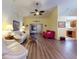 Bright living room with vaulted ceiling, ceiling fan, wood flooring, and access to kitchen, perfect for gatherings at 686 Middlebury Loop, New Smyrna Beach, FL 32168