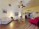 Spacious living room with hardwood floors, comfortable seating, and a ceiling fan at 686 Middlebury Loop, New Smyrna Beach, FL 32168
