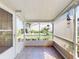 Enclosed porch featuring neutral tile flooring, screen windows for natural light, and views to the lush, landscaped yard at 686 Middlebury Loop, New Smyrna Beach, FL 32168