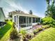 Enclosed patio surrounded by lush garden with potted plants, offering a private and relaxing outdoor space at 686 Middlebury Loop, New Smyrna Beach, FL 32168